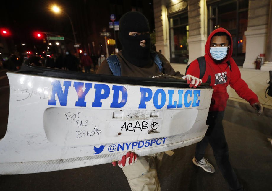 Протестующие несут бампер полицейского автомобиля в Нью-Йорке во время беспорядков, 31 мая 2020 