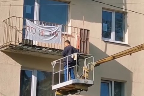 В Минске коммунальщики сняли с балкона ткань с надписью "Это не флаг"