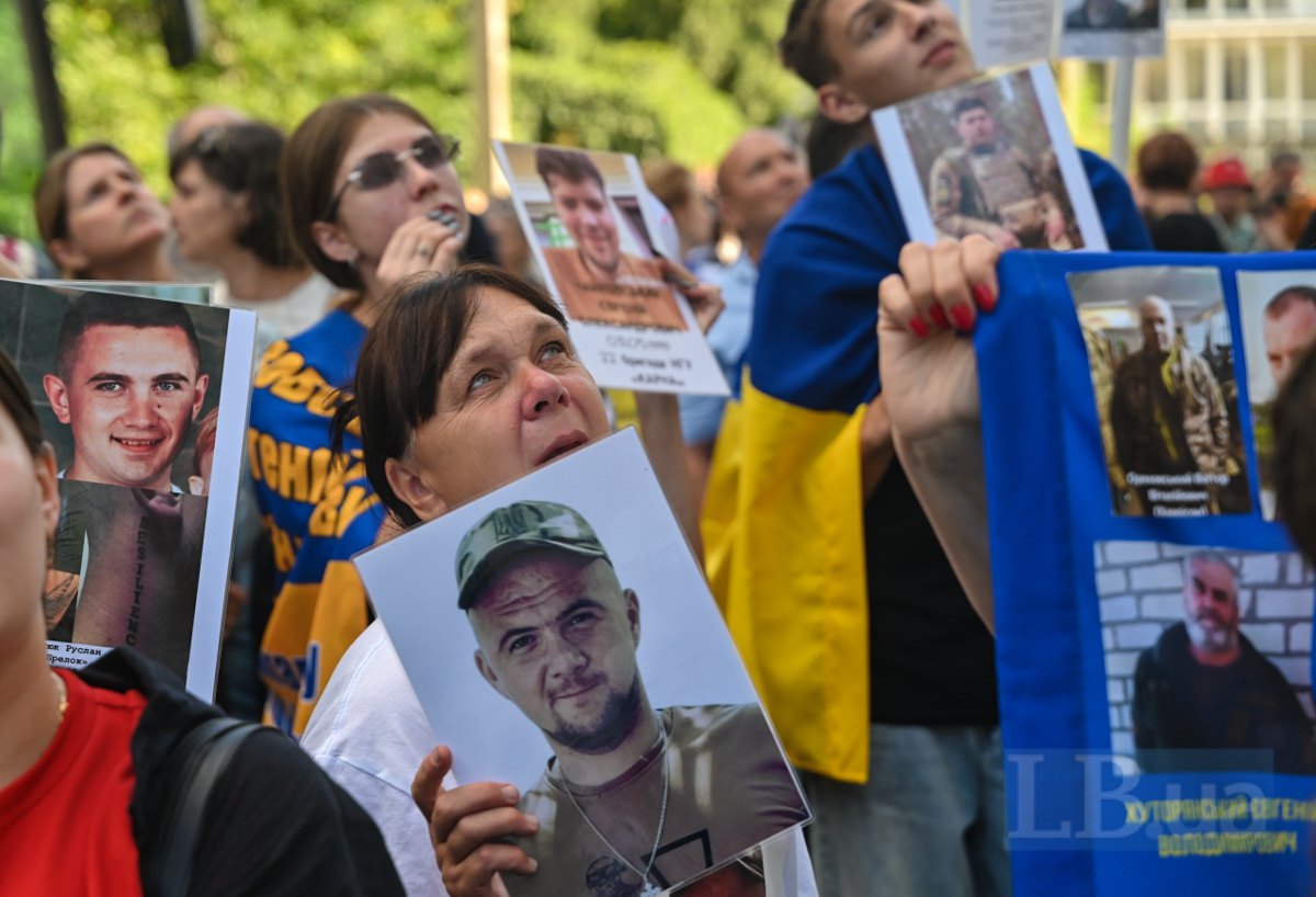 Люди, які зібралися під вікном будівлі в очікуванні українців, звільнених з полону