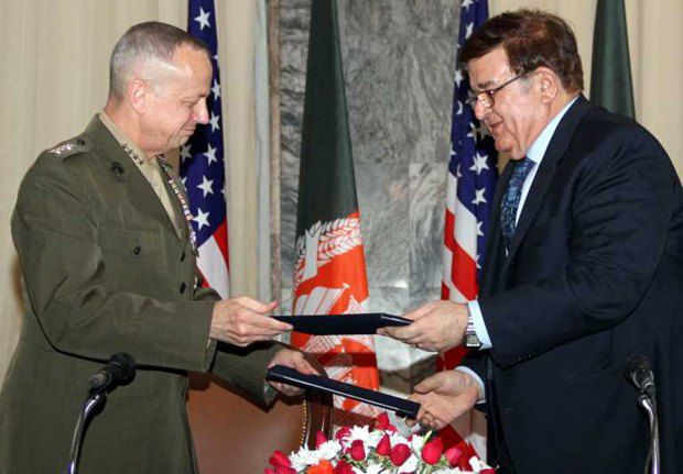 Командующий американскими военными силами в Афганистане (слева) и министр обороны Афганистана обмениваются документами после
подписания меморандума