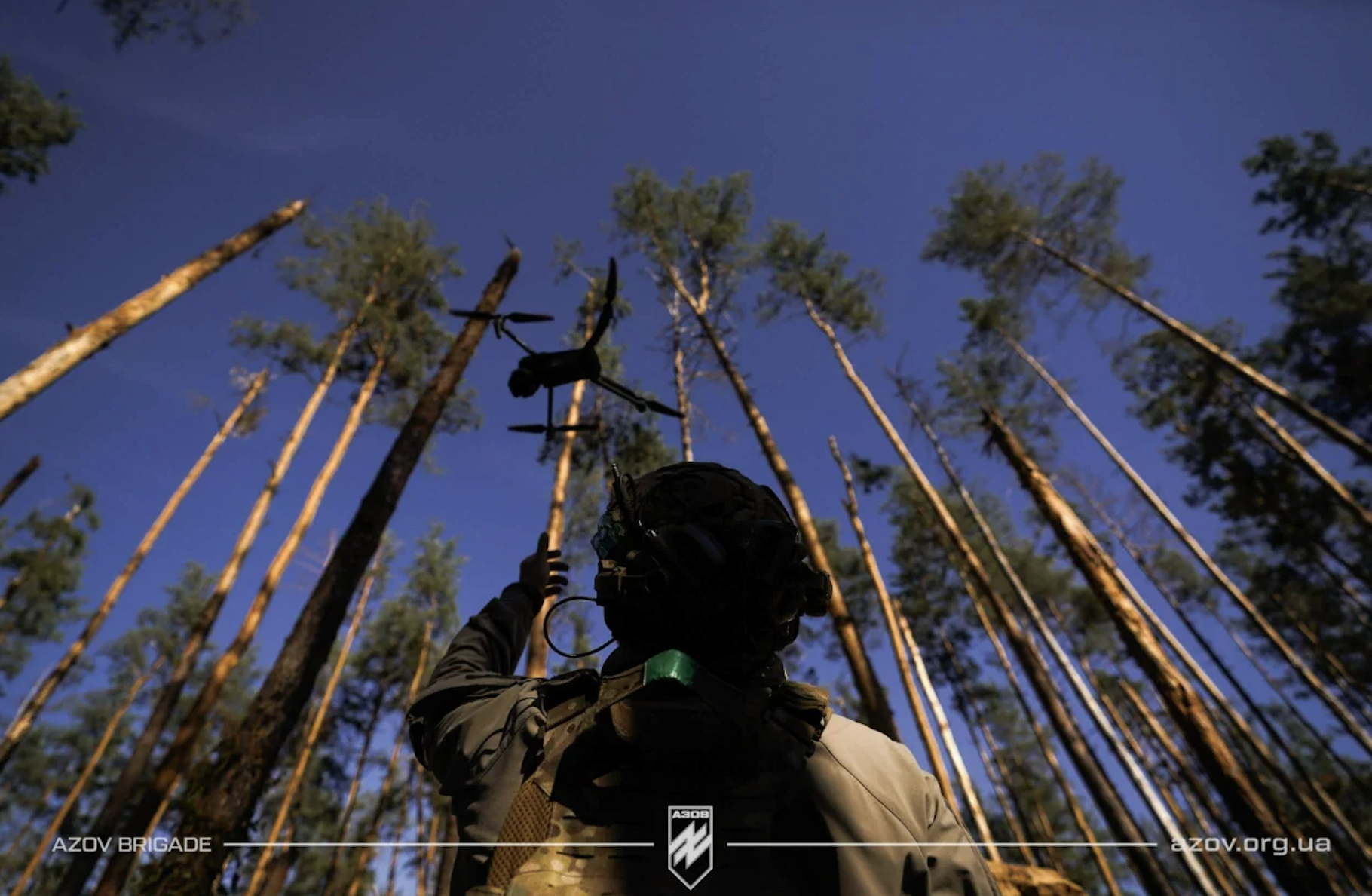 Азовець запускає в небо дрон на фоні лісу