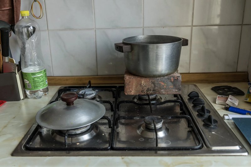 Родина Гончаруків намагаюється обігріти свою квартиру, розігріваючи цеглину й каструлю з водою на газовій плиті, Київ, січень 2026 