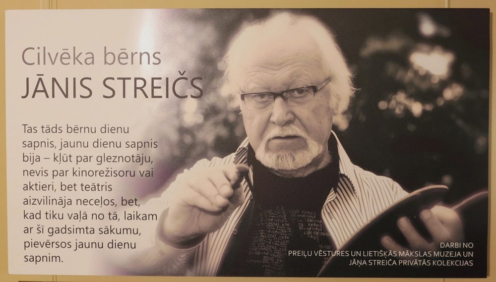 Постер виставки картин Стрейча «Дитя людське Яніс Стрейч». Серпень 2026 року. (В темі виставки використана назва фільму кінорежисера, знятого в 1991-му).