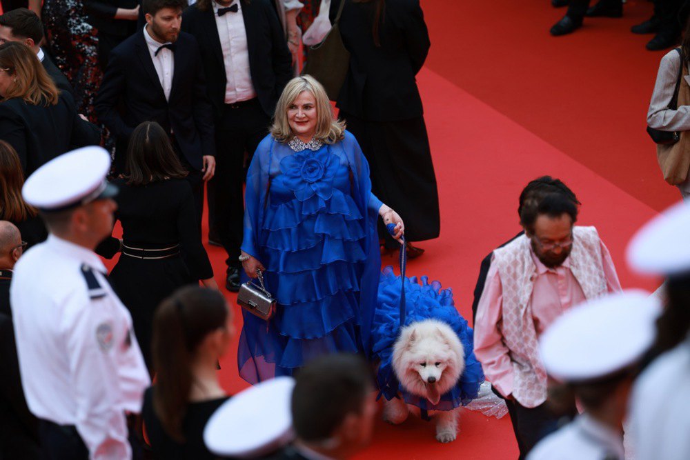Гостя церемонії зі своєю собакою під час відкриття 78-го Каннського кінофестивалю 