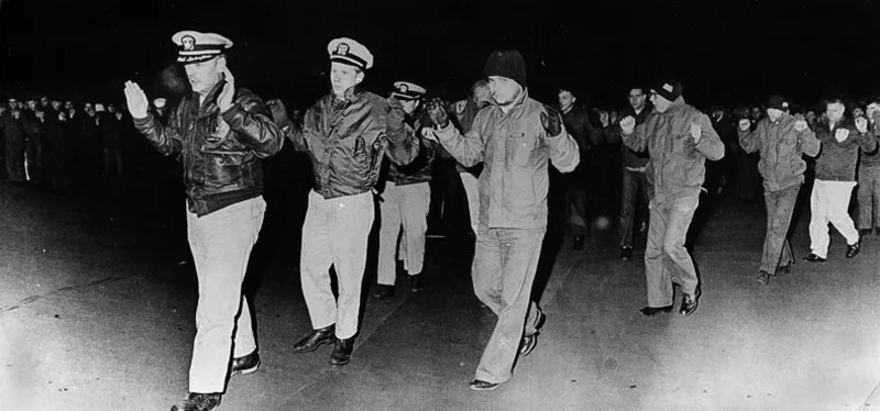 Командир USS Pueblo Лейтенант Ллойд Бучер та члени екіпажу прибувають до Північної Кореї після захоплення судна 23 січня 1968 року.