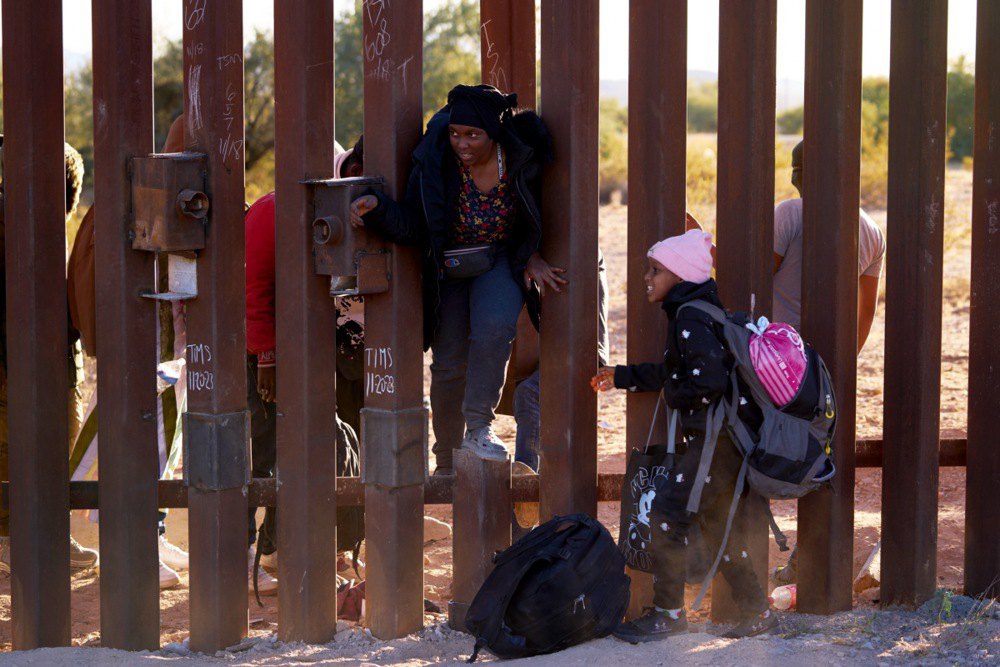 Мігранти пролазять через паркан на кордоні Мексики та США в Люквіллі, штат Арізона, 12 грудня 2023 р.