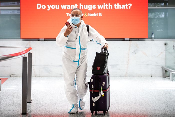 Мандрівник у захисному одязі прибуває до міжнародного аеропорту Сіднея, Австралія, 29 листопада 2021 року