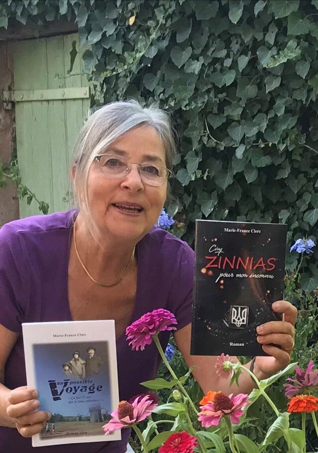 Марі-Франс і дві її книжки на тлі майорців (циній) — популярних квітів як в Україні, так і у Франції