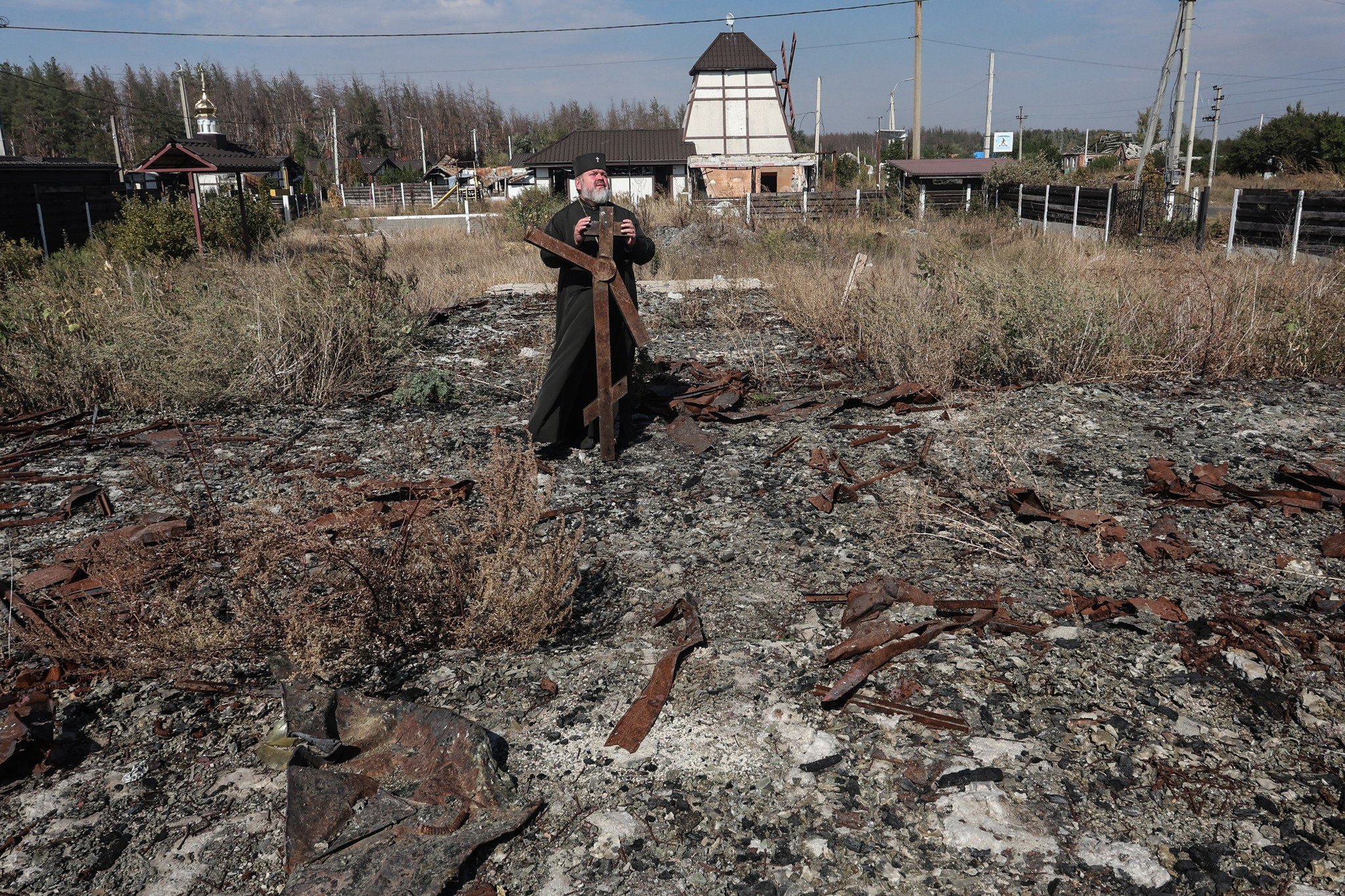 Архієпископ Митрофан на попелищі храму, знищеному ворогом.