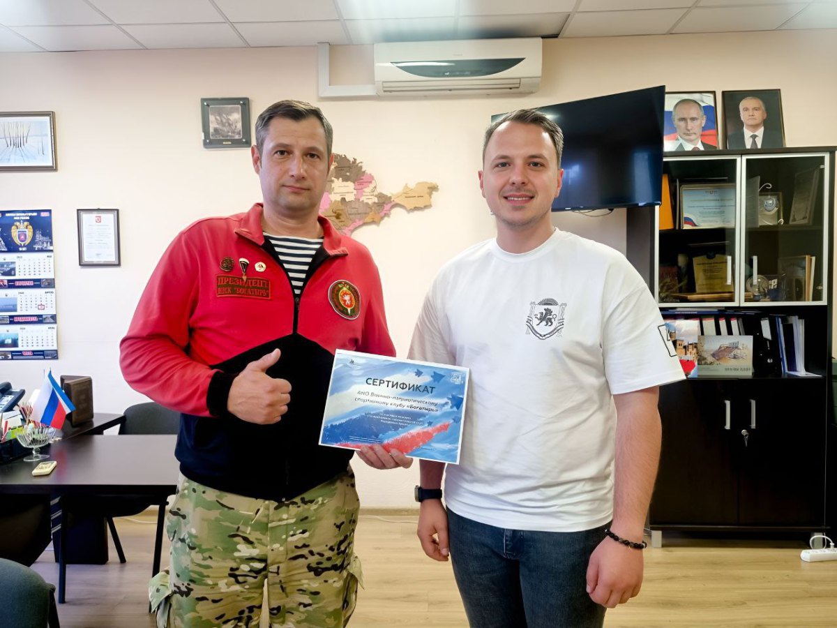 Олексій Зінченко, так званий голова Держкомітету молодіжної політики Республіки Крим (у білій футболці) вручає сертифікат за участь у конкурсі Олексію Ілляшенку, керівнику ВПК «Богатир» і колишньому працівнику Головного управління МНС України в АР Крим