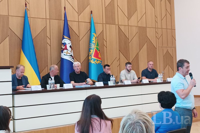 Заступник голови КМДА Вячеслав Непоп, голова Святошинської РДА Георгій Зантарая (в центрі) з чиновниками на зустрічі з
мешканцями Кучера, 2-А