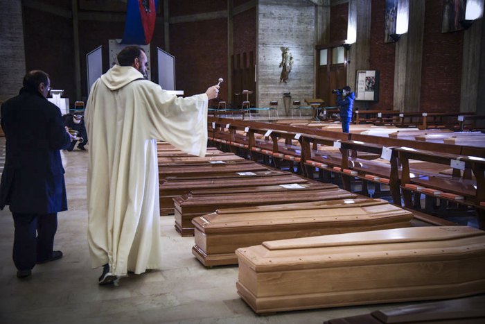 Священик під час поминальної служби за померлими від COVID-19