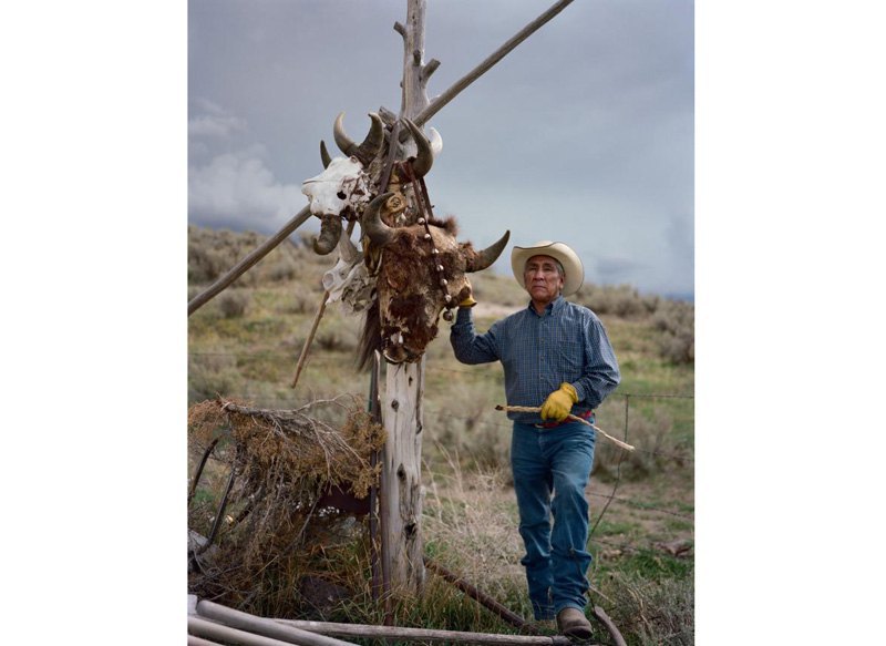 Леон Тетон возле столба с черепами бизона, символизирующим духовную связь между племенем Шошон-Баннок и бизоном, Айдахо.