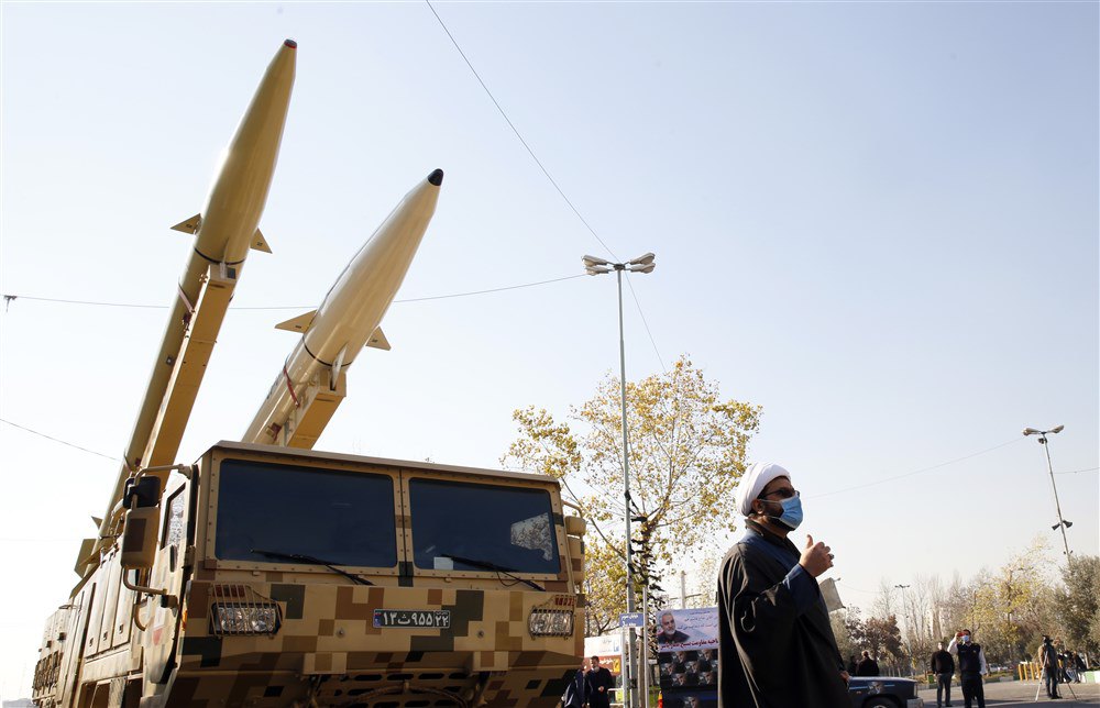 Іранський священнослужитель стоїть поруч із ракетами Zolfaghar-Basir (ліворуч) і Dezful (праворуч), виставленими на огляд з нагоди другої річниці ракетного удару Ірану по американській військовій авіабазі Айн аль-Асад в Іраку, Тегеран, 7 січня 2022 р. 
