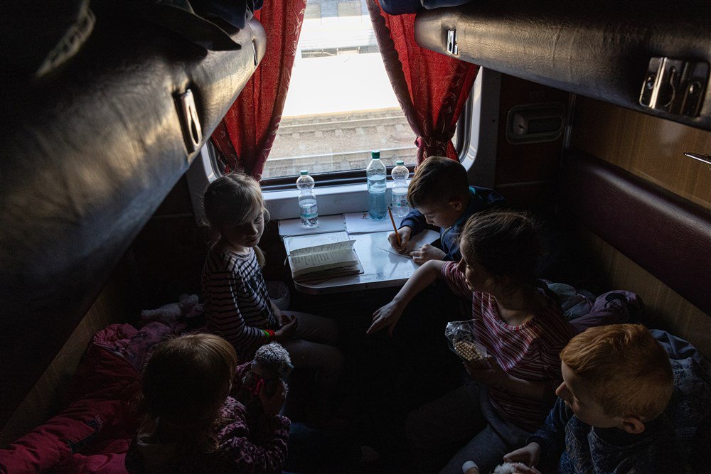 Діти-сироти з окупованого міста Пологи їдуть в евакуаційному поїзді, який прямує на захід України із Запоріжжя, 26 березня 2022 року