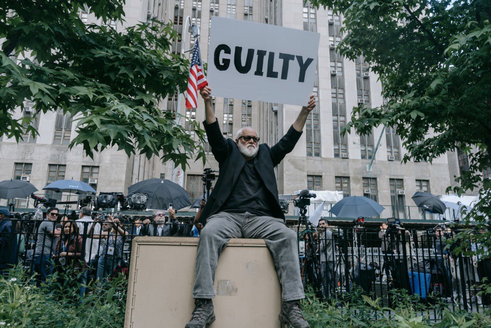 Протестувальник проти Трампа біля будівлі суду