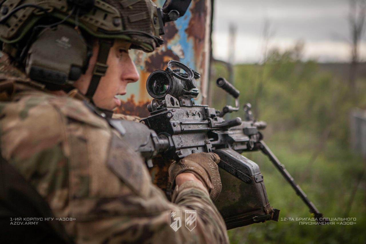 Військовослужбовець готується до пострілу з автомата, дивлячись у приціл