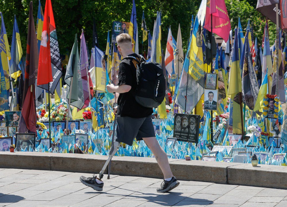 Молодий протезований ветеран проходить повз Народний меморіал загиблим захисникам України на майдані Незалежності в Києві.