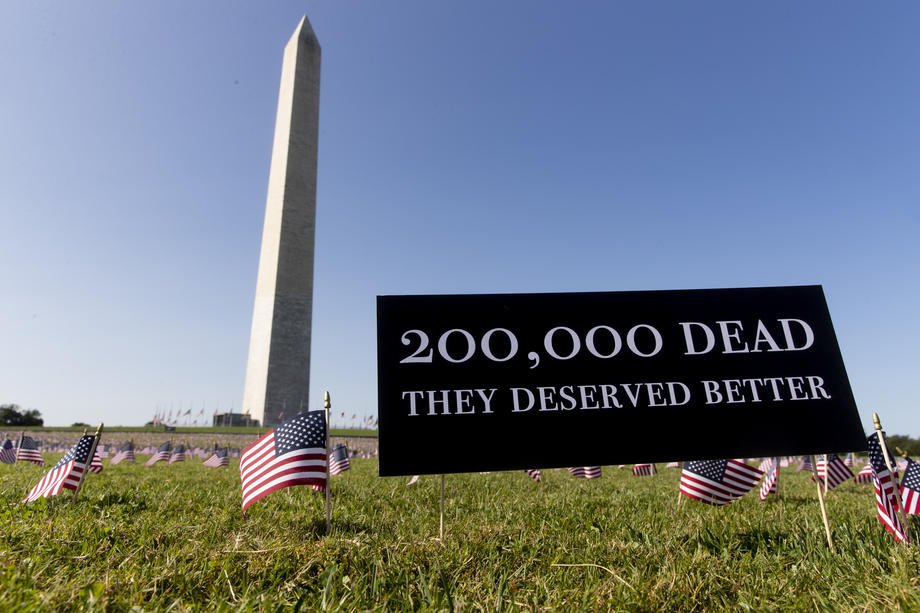 Табличка с надписью ‘200 000 погибших. Они заслуживали лучшего’ видна среди флагов, установленных в память об американцах,
погибших от COVID-19, возле памятника Вашингтону на Национальной аллее в Вашингтоне, США, 22 сентября 2020 г