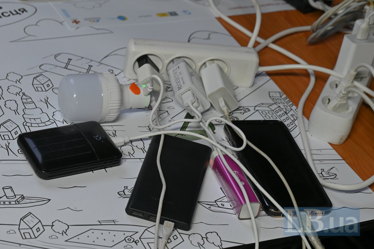 Павербанки та інші пристрої заряджаються в одному з пунктів незламності в Києві.