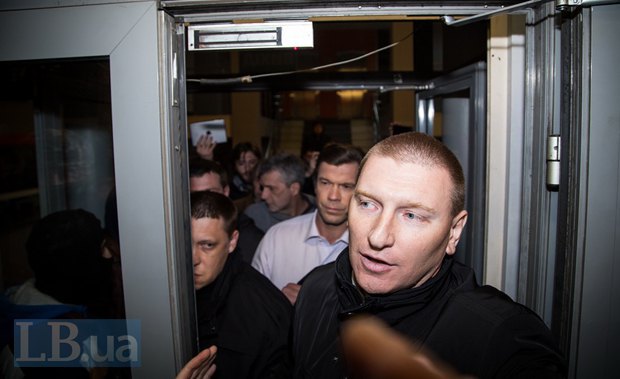 Олег Царев выходит из здания в сопровождении охраны
