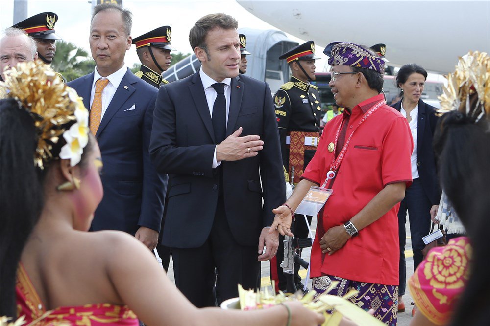 Губернатор Балі Ваян Костер (справа) вітає президента Франції Емманюеля Макрона після прибуття в міжнародний аеропорт Нгурах-Рай напередодні саміту G20 на Балі, Індонезія, 14 листопада 2022 року.