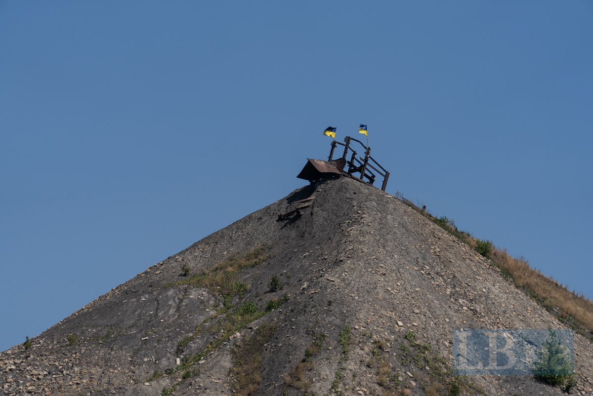 Українські прапори майорять над териконом у Добропіллі, поблизу лінії зіткнення.