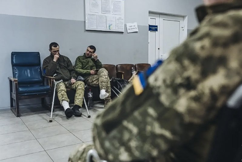 Військовослужбовці очікують в черзі в медустанові.