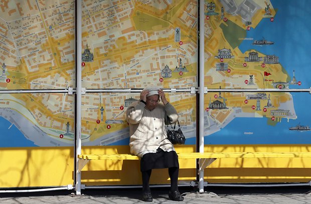 Пенсионерка на остановке общественного транспорта в Севастополе