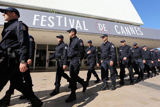 Полицейские проходят мимо Дворца фестивалей, где уже завтра пройдет церемония открытия 66-го Каннского кинофестиваля