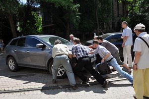 В Донецке люди на руках вынесли автомобиль, припаркованный на трамвайных путях