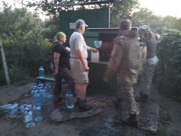 Наполняем бутыли водой из колодца