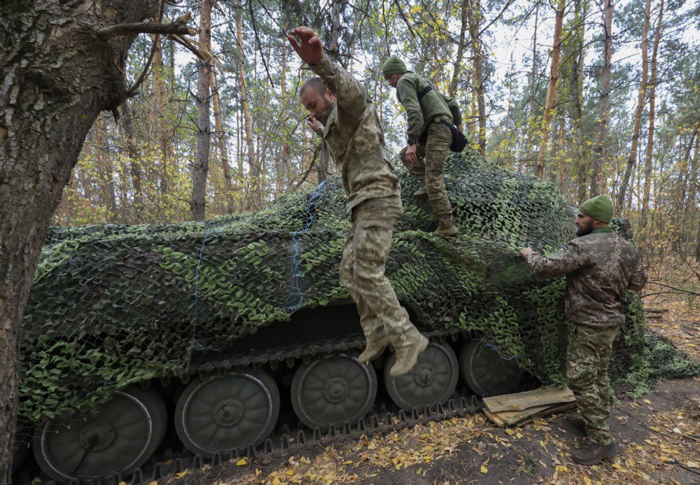 Військовослужбовці 154 окремої механізованої бригади прикривають маскувальною сіткою САУ 2С1 «Гвоздика» на передовій у Харківській області, 9 жовтня 2024 р.