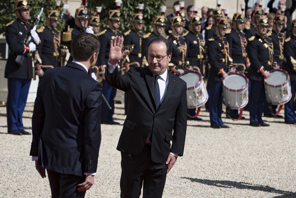 Новий президент Франції Емманюель Макрон (ліворуч) прощається з колишнім президентом Франсуа Олландом під час церемонії передачі влади в Єлисейському палаці в Парижі, 14 травня 2017 року.