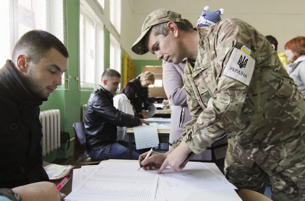 Військовослужбовець отримує виборчий бюлетень під час голосування на парламентських виборах, 26 жовтня 2014
року.