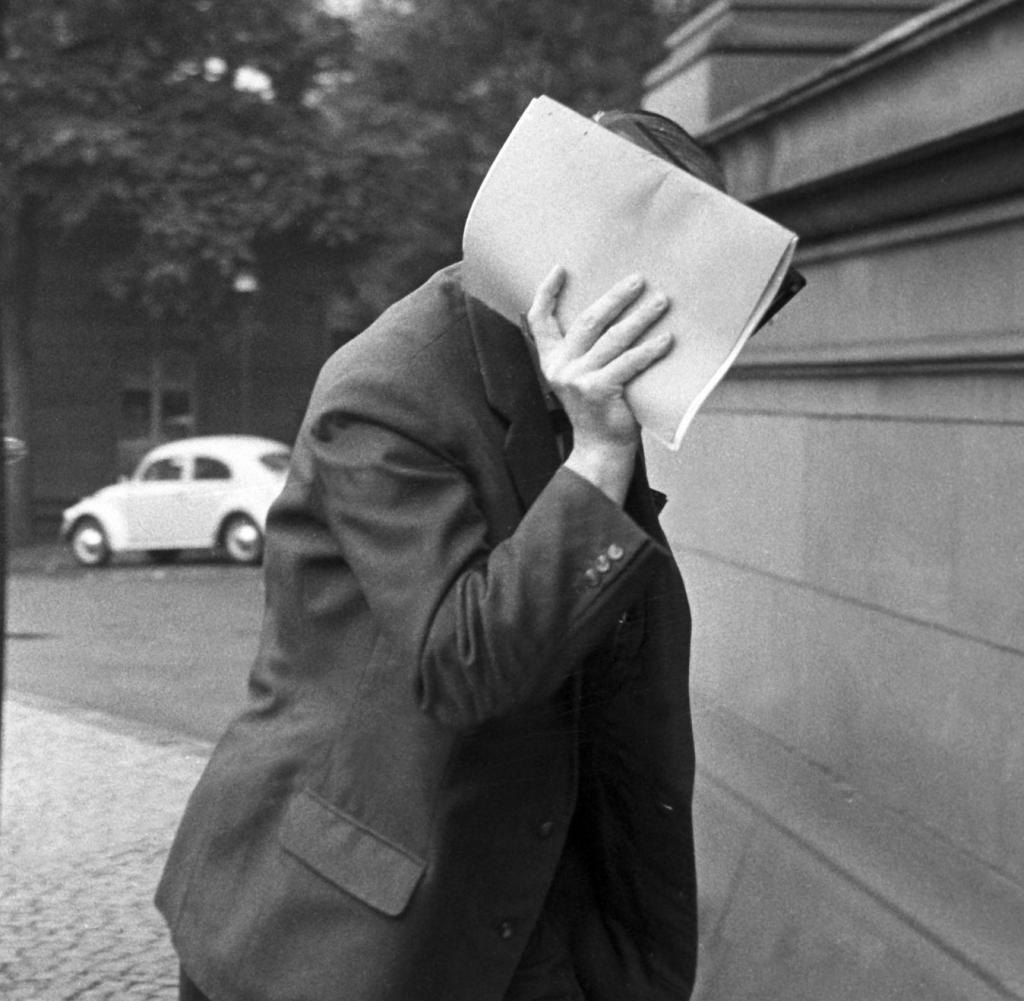По дорозі до суду в 1963 році Фельфе прикриває обличчя папкою.