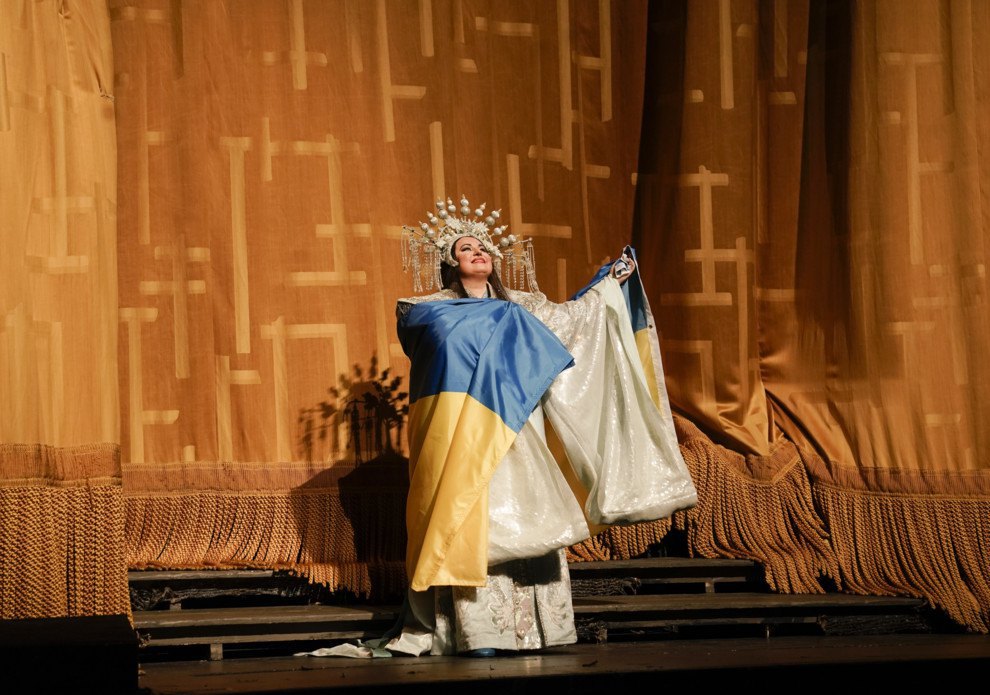 Українська оперна співачка Людмила Монастирська вийшла на поклон на сцену нью-йоркської Metropolitan Opera, загорнута у величезний український прапор, після опери Пуччіні ‘Турандот’.
