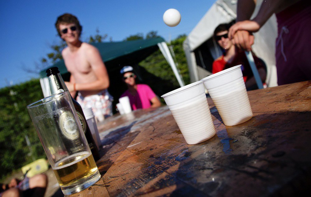 Молодь розважається грою в <i>Beer Pong</i> (потрібно влучити м’ячиком для пінг-понгу в келих з пивом — і тоді його можна випити) в кемпінгу в Шарендійке, Нідерланди.