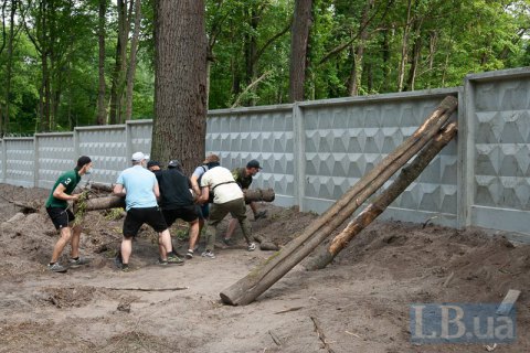 В Пущі-Водиці пройшла акція проти ЖК посеред лісу: бетонний паркан пробили колодою