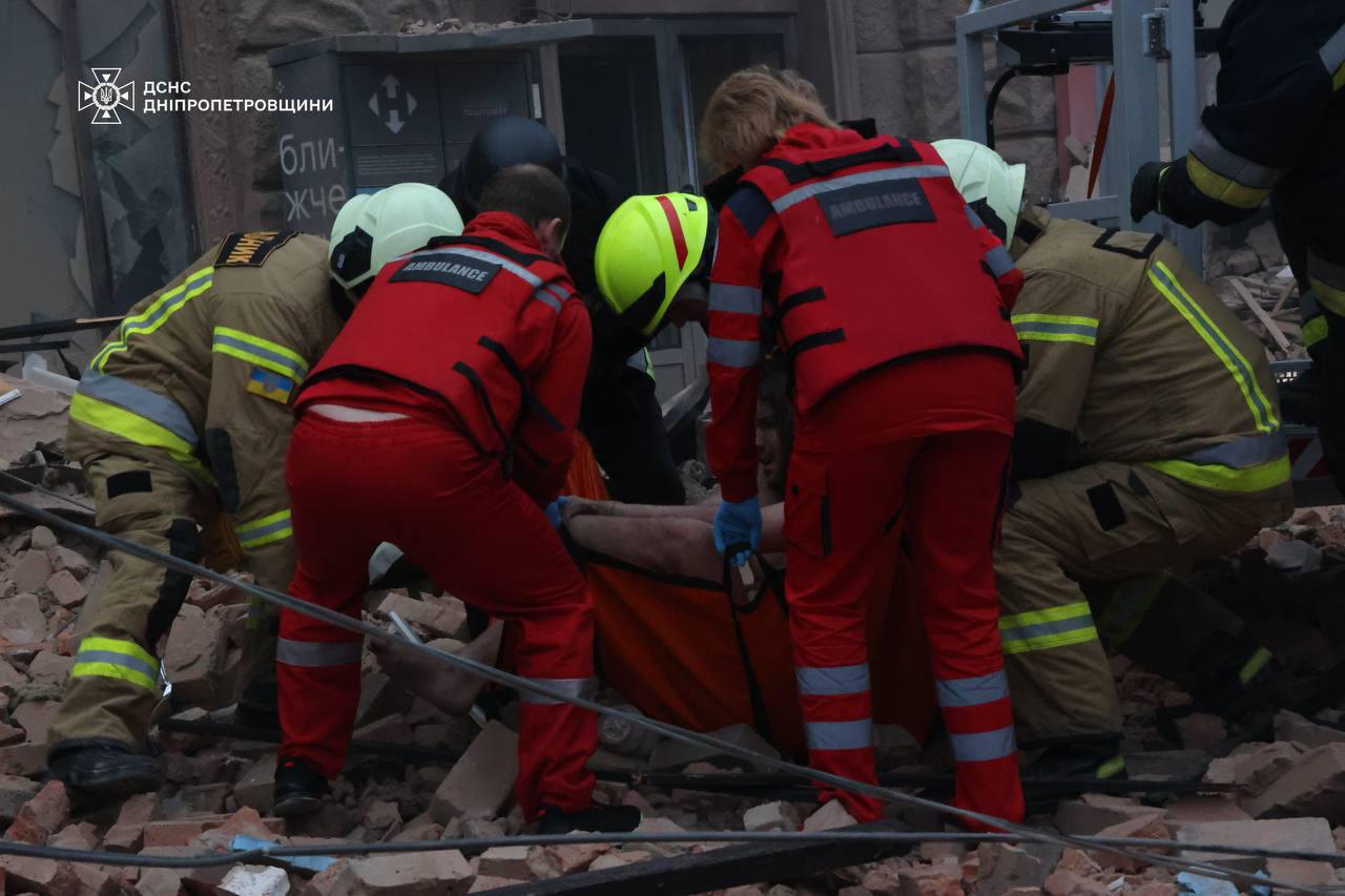 Рятувальники евакуйовують пораненого внаслідок атаки по Дніпру 19 квітня