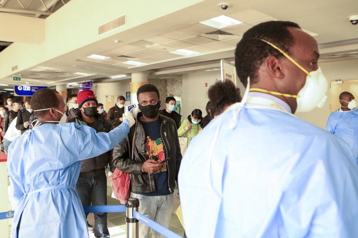 Медработники меряют температуру у пассажиров, прибывших в международный аэропорт в Найроби, Кения, 29 января 2020.