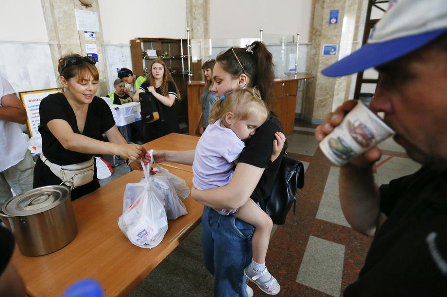 Переселенці з Миколаєва та родини, яким вдалося втекти з тимчасово окупованих територій, отримують допомогу на залізничному вокзалі Одеси, 2 червня 2022 року, перед тим як рушити на захід України або за кордон.