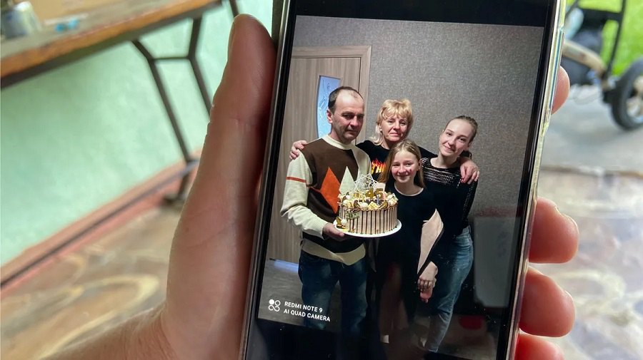 Вдова Віталія Кібукевича показує фотографію своєї родини