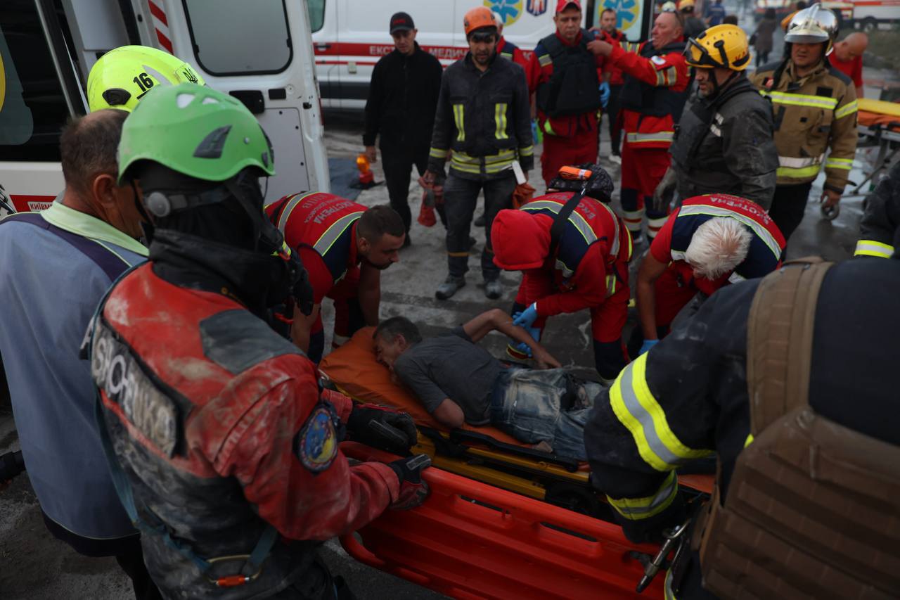 Рятувальники надають допомогу постраждалому на місці удару.