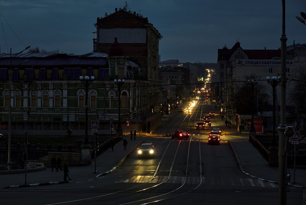 Автівки їдуть у темряві під час відключення світла, центр Харкова, 24 березня 2024 р.