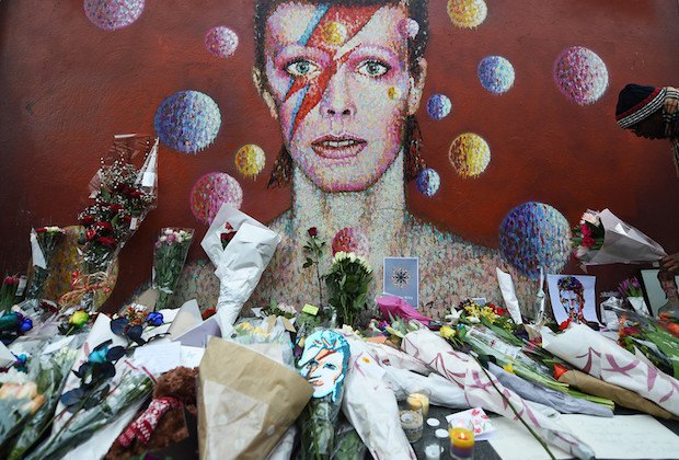 Поклонники несут цветы к стене в лондонском районе Брикстон, где Боуи родился