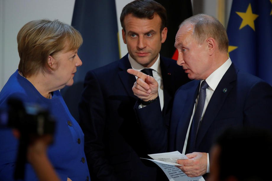 Президент России Владимир Путин делает жест рядом с президентом Франции Эммануэлем Макроном и канцлером Германии Ангелой Меркель на совместной пресс-конференции после саммита в нормандском формате в Париже, Франция, в начале 10 декабря 2019 года.