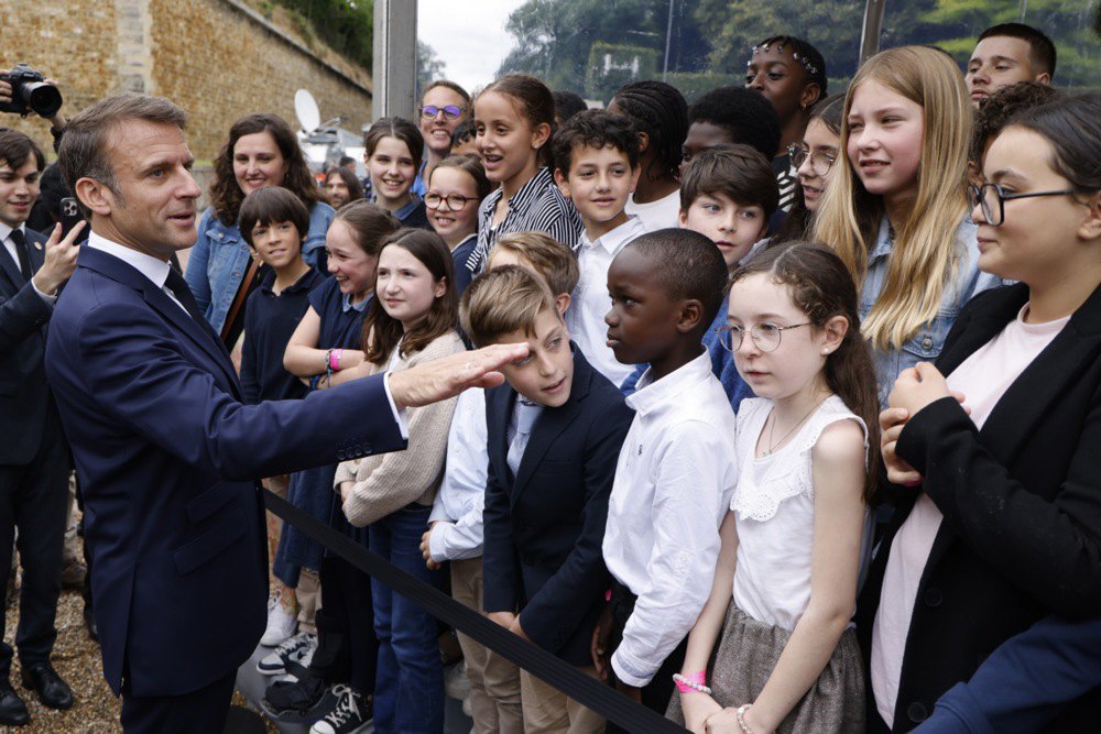 Президент Франції Емманюель Макрон вітає школярів на церемонії біля меморіалу Мон-Валер’єн у Сюрені, поблизу Парижа, 18 червня 2024 р.