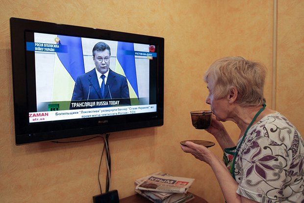 Жительница Симферополя смотрит трансляцию заявления Януковича по телевизору