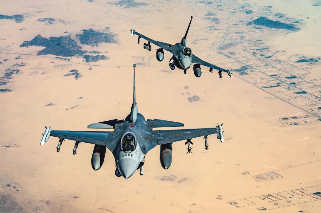 Два винищувачі <i>F-16 ВПС</i> США з ракетним спорядженням класу повітря — повітря на Близькому Сході 11 лютого 2025 року. У літака позаду під правим крилом пара семизарядних 70-міліметрових ракетних блоків